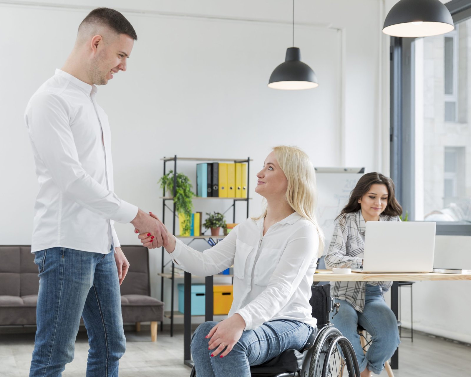 woman-wheelchair-shaking-hand-with-coworker